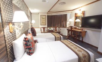 a hotel room with two beds , a television , and a dining table , all decorated in a traditional style at Han She Business Hotel