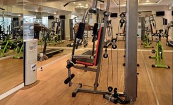 a well - equipped gym with a variety of exercise equipment , including weights , a treadmill , and a stationary bike at Savero Hotel Depok