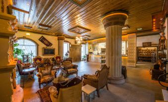 a large , elegant living room with wooden ceiling , stone floors , and various pieces of furniture at Kapadokya Hill Hotel & Spa (12+)