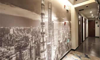In an office with hardwood floors and glass partitions, there is a large mural on the wall at Meego Yes Hotel