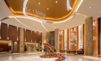 The lobby or atrium area features a spacious room adorned with an artistic ceiling and chandelier at Ramada by Wyndham Heze