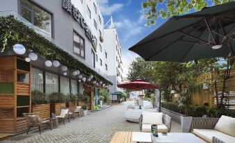 In the city center, there is an outdoor restaurant with a patio featuring tables and chairs at Campanile Hotel (Shanghai Jing'an)