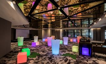 a large room with a variety of colorful lights on the ceiling and floor , creating an interesting and unique atmosphere at Capri by Fraser Brisbane