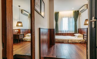 The bedroom features wooden floors, large windows, and an open door next to the bed at Poshpacker Flipflop Youth Hostel (Taikoo Li Chunxi Road Metro Station)
