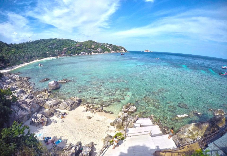 a scenic view of a beach with clear blue water and white sand , taken from an aerial perspective at Taatoh Seaview Resort