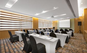 a conference room set up for a meeting , with tables and chairs arranged in rows at Holiday Inn Express