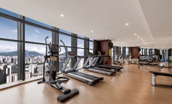 This modern-style home features a gym with large windows that offer views of the city, as well as various fitness equipment at Shenzhen Huaqiang Plaza hotel (Huaqiangbei Metro Station)