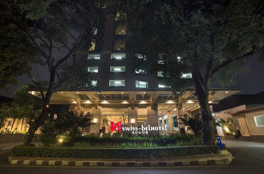 "a large building with a sign that reads "" swiss - belhotel "" is surrounded by trees and bushes" at Swiss-Belhotel Bogor