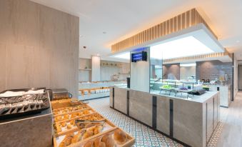 The restaurant features a wide variety of food displayed on the counter, complemented by an open concept layout at Yiwu Mankalan Hotel (International Trade City Xinguanghui Branch)