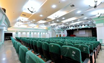 There is an empty auditorium with rows of seats and a large screen in the middle, facing another room at Metropolo Jinjiang Hotel Classiq (Shanghai Nanjing Road Pedestrian Street)