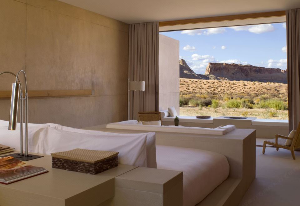 a bedroom with a bed and a large window overlooking a desert landscape , creating a serene and relaxing atmosphere at Amangiri