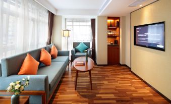 The modern living room features wood paneling and a centrally placed L-shaped couch at Zhenyue Hotel