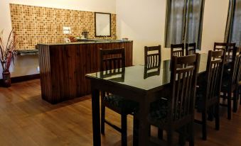 a dining room with a wooden table and chairs , a counter with a sink , and a kitchen area at Windsongs