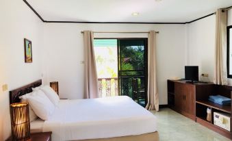 a hotel room with a double bed , a television , and a window overlooking the outdoors at Dolphin Bay Beach Resort