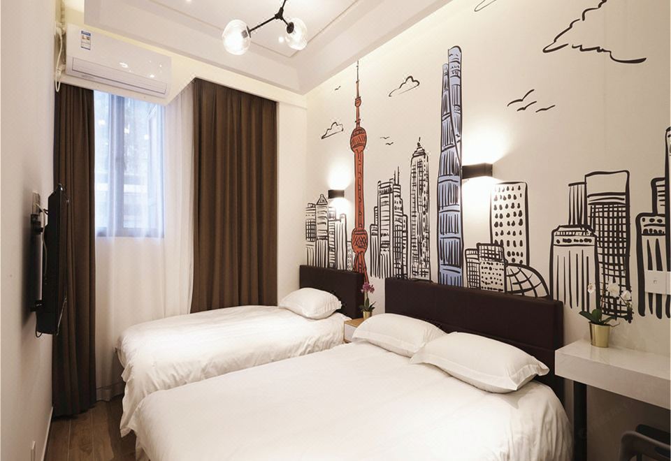The bedroom features large beds and white painted walls, with an artistic element beside the bed at Meego Yes Hotel