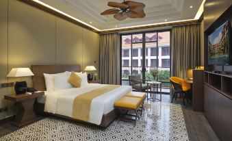 a luxurious hotel room with a king - sized bed , a large window , and a balcony overlooking the city at Senna Hue Hotel