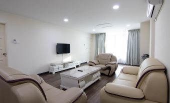 a modern living room with white furniture , including two couches and a coffee table , along with a tv on the wall at Higher Hotel