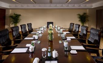 The hotel offers a spacious conference room equipped with long tables and brown chairs, suitable for hosting meetings and corporate events at Best Western Premier Ocean Hotel