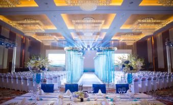 a luxurious wedding reception with white and blue decor , including chandeliers , flowers , and blue tablecloths at Sheraton Qinhuangdao Beidaihe  Hotel