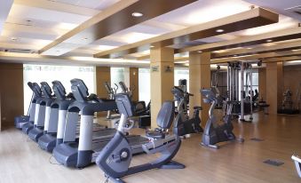 a well - equipped gym with various exercise equipment , including treadmills and stationary bikes , in a spacious room with wooden flooring at Pearl Continental Hotel, Lahore