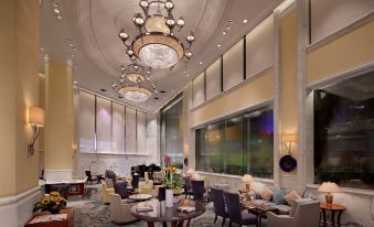 a luxurious hotel lobby with high ceilings , multiple seating areas , and a large chandelier hanging from the ceiling at Hotel Royal