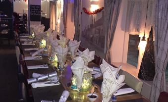 a long dining table set up for a party , adorned with various decorations and utensils at The Willow House