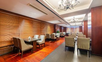 The restaurant features an open concept dining room with tables and chairs in the middle at Byland World Hotel (Yiwu International Trade City)