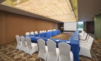A spacious event room is arranged with blue chairs and long rectangular tables at Radisson Blu Hotel Shanghai New World