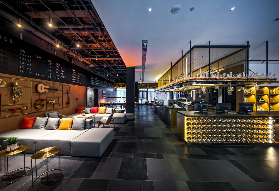 The restaurant is located in the middle of the space, next to an open concept living room, featuring tables and chairs at CitiGO Hotel Beijing Tian'anmen Square
