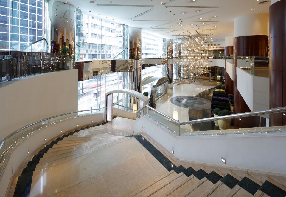 The large building features a lobby and staircase with floor-to-ceiling glass panels on both floors at B P International