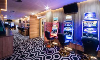 a room with various gaming machines and chairs , possibly in a casino or a gaming area at Airlie Beach Hotel