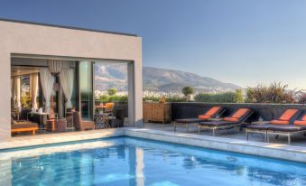 a modern house with a swimming pool , surrounded by a balcony and with a view of the mountains in the distance at President Hotel