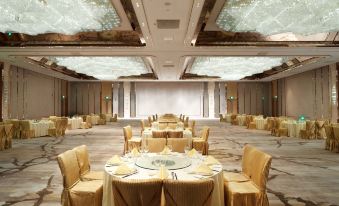 A spacious room is arranged with tables and chairs for an event at the hotel or conference at International Youth Convention Hotel (Nanjing International Youth Cultural Centre)
