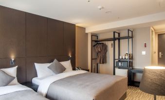 a hotel room with a king - sized bed and a closet , along with various items such as a nightstand and a lamp at Hotel Foret Premier Nampo