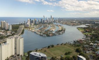 a city skyline with a large body of water and several buildings , including a marina at Meriton Suites Southport