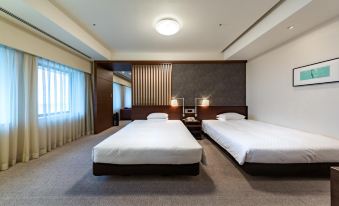a hotel room with two beds , a nightstand between them , and large windows on one side at Centrair Hotel