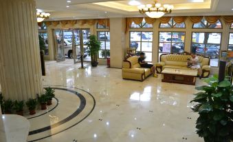 a large , well - lit hotel lobby with multiple couches and chairs arranged in a comfortable seating area at Vienna Hotel