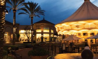 a large shopping mall with an outdoor dining area and a carousel in the center at Fairfield Inn & Suites by Marriott Tustin Orange County