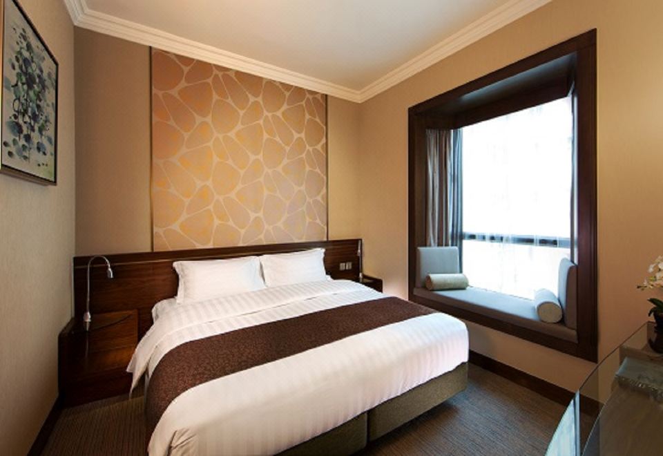 The bedroom features large windows and a double bed with a king-size headboard at Rosedale Hotel Hong Kong