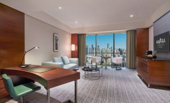 A room furnished as an office with large windows, a couch, and a chair in front at Amara Signature Shanghai
