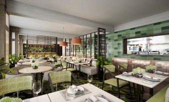 a modern restaurant with green and white tiled walls , modern dining tables , and chairs at DoubleTree by Hilton Wellington