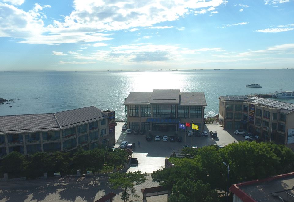 The balcony offers a scenic view of the ocean and surrounding buildings on both sides at Beidaihe Bei Hua Yuan Sea View Hotel (Beidaihe Biluo Tower)