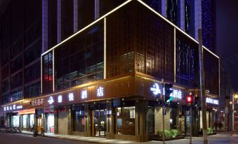 The exterior view at night showcases a large building in front with an illuminated sign at Zhenyue Hotel