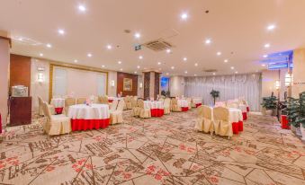 A ballroom at the hotel is arranged for an event, featuring tables and chairs in the front at UChoice Hotel
