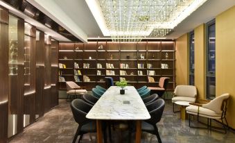 The room is equipped with bookshelves, tables, and chairs for guests to comfortably read books or work on their laptops at Atour Hotel