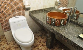 The bathroom in the middle is decorated in an oriental style and features a toilet, sink, and counter at Tongtong Hotel