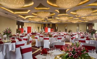 A ballroom is arranged for an event, with tables and chairs placed in the center at Swissotel Foshan Guangdong