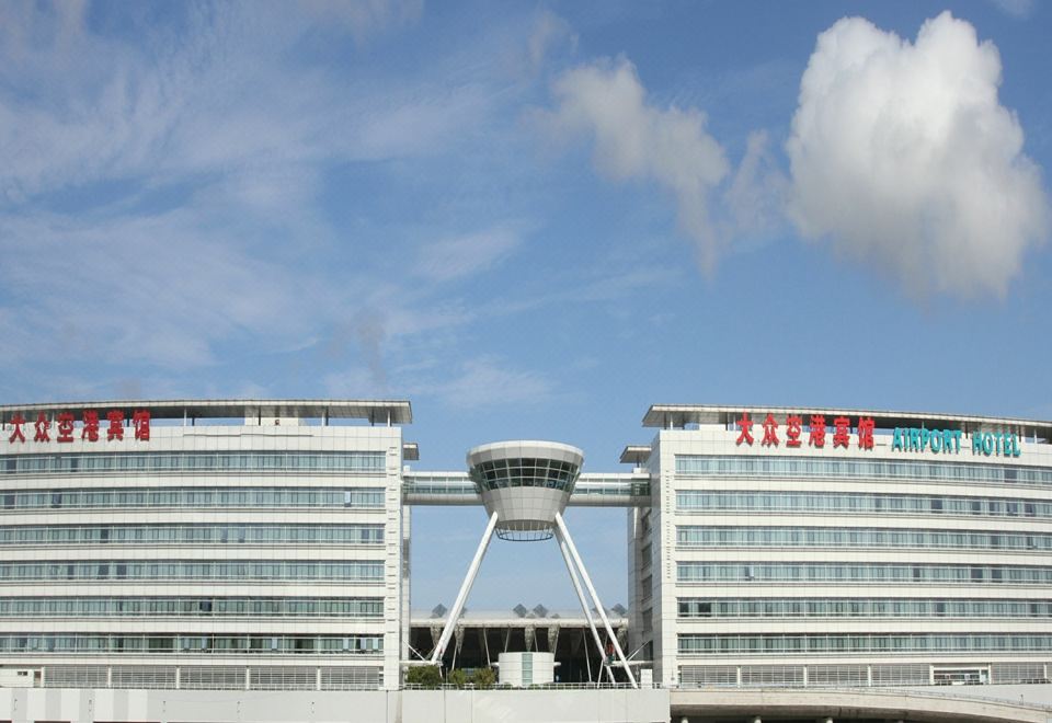 "A large building with a sign that says ""hotel"" on top and another sign in front" at Da Zhong Airport Hotel