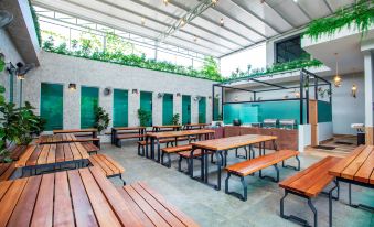 an empty , well - lit indoor space with wooden benches and green plants , creating a modern and inviting atmosphere at Bzz Hotel Skudai