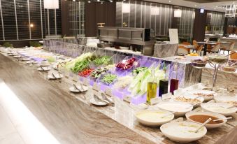 a long dining table with a variety of food items , including salads , fruits , and vegetables at Hotel Cham Cham - Taipei